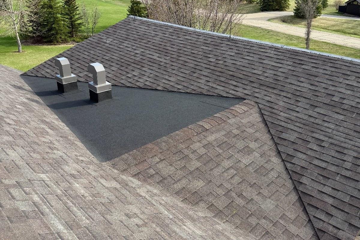 Close-up of quality roof installation — architectural shingles, vents, and flashing on a Calgary-region home.
